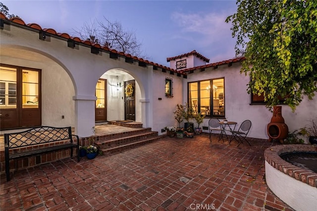 1731 W Kenneth Rd, Glendale, CA 91201 - back of house at dusk with stucco siding, french doors, a tiled roof, and a patio