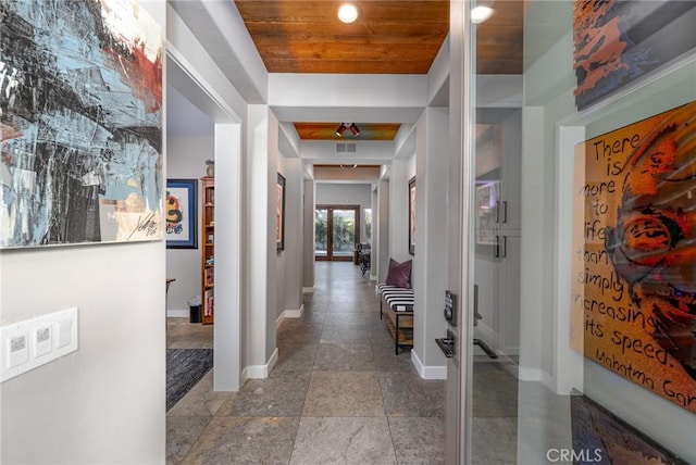 corridor with baseboards and wooden ceiling