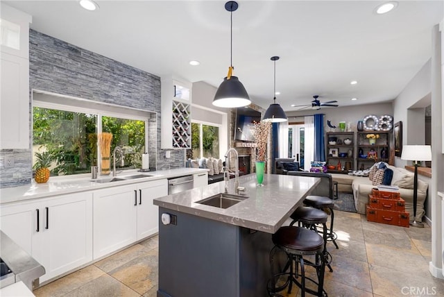 kitchen featuring a sink, tasteful backsplash, recessed lighting, and stone tile floors