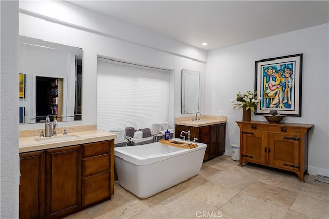 bathroom featuring two vanities, a soaking tub, and recessed lighting