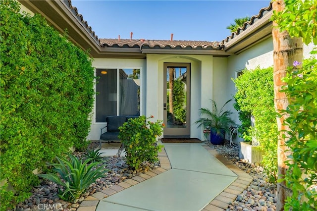 9 Via Dulcinea, Dulcinea, Palm Desert, CA 92260 - view of exterior entry with stucco siding, a tiled roof, and a patio