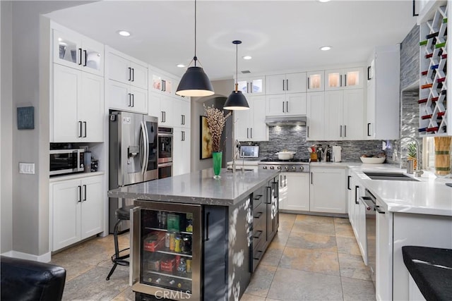 9 Via Dulcinea, Dulcinea, Palm Desert, CA 92260 - kitchen featuring wine cooler, appliances with stainless steel finishes, backsplash, stone tile floors, and a sink