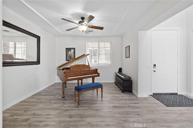 foyer entrance featuring light wood-style floors, ceiling fan, and baseboards