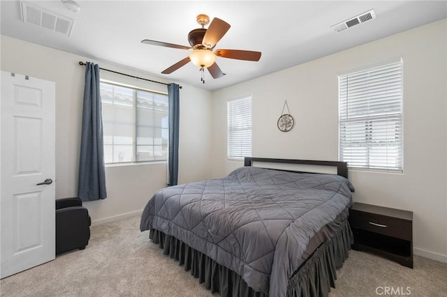 bedroom featuring light colored carpet, multiple windows, and baseboards