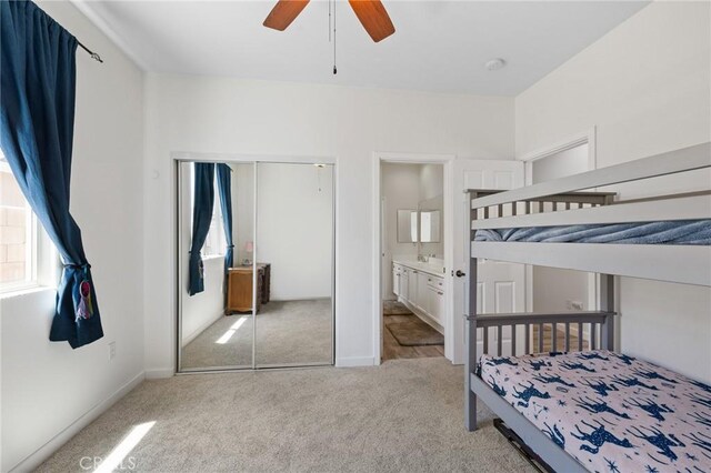 carpeted bedroom featuring a closet, ceiling fan, baseboards, and connected bathroom