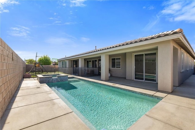 view of swimming pool featuring a patio area, a fenced backyard, and a pool with connected hot tub