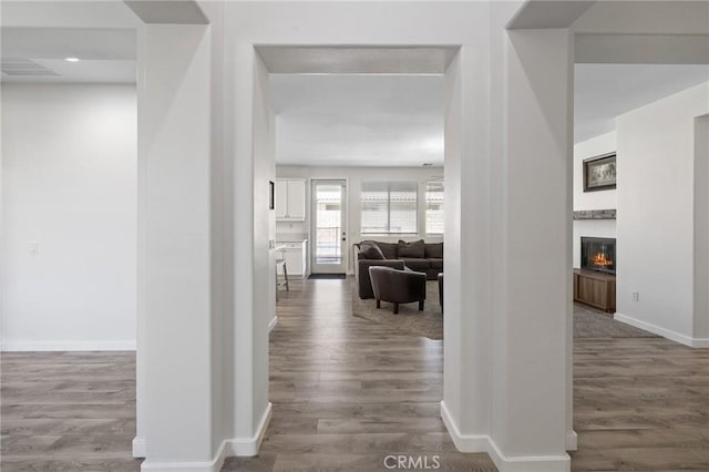 hallway with wood finished floors, baseboards, and recessed lighting
