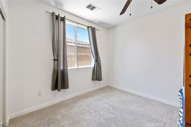 spare room featuring ceiling fan, carpet, and baseboards