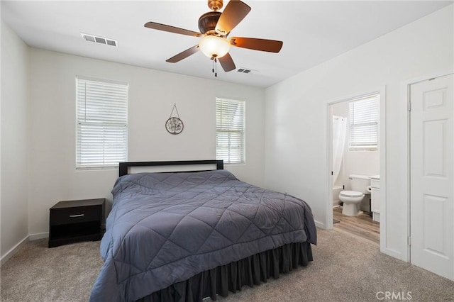 bedroom with carpet flooring, ensuite bathroom, baseboards, and ceiling fan