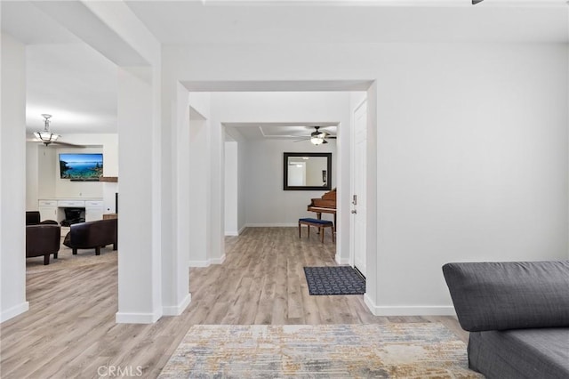 hall with light wood-style flooring and baseboards