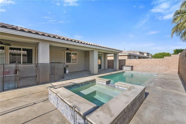 view of swimming pool featuring a ceiling fan, a patio area, a fenced backyard, and a pool with connected hot tub