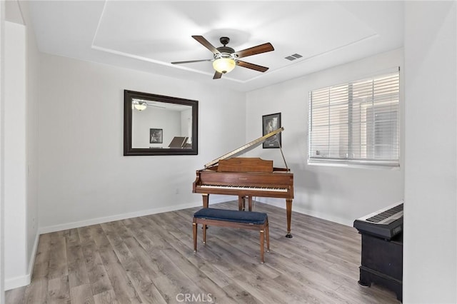 sitting room with a ceiling fan, wood finished floors, and baseboards