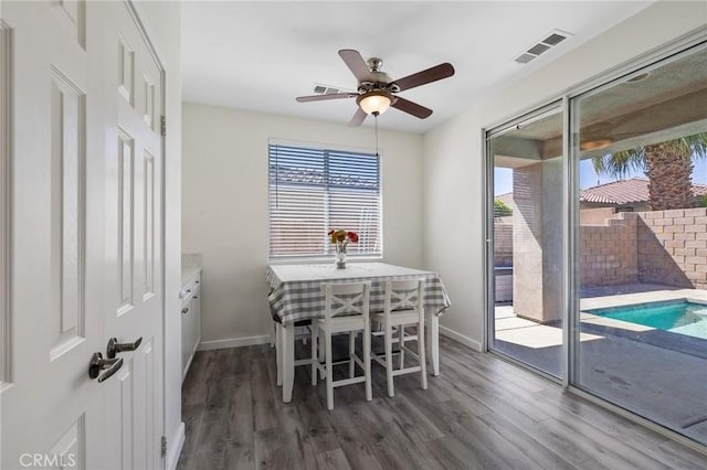 dining space with healthy amount of natural light, wood finished floors, and ceiling fan