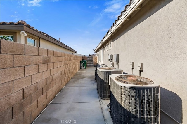 view of property exterior with stucco siding, cooling unit, and fence