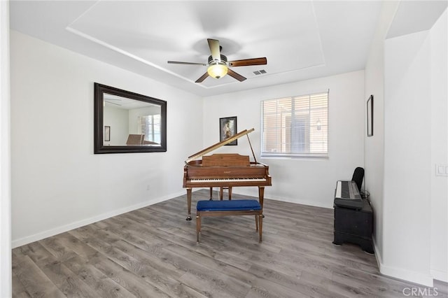 living area with plenty of natural light, wood finished floors, and a ceiling fan