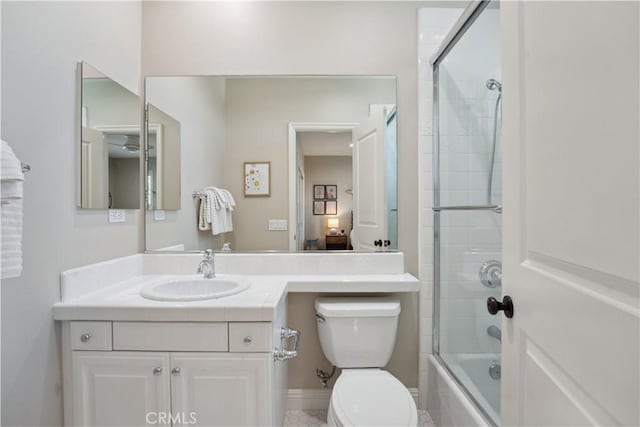 full bathroom featuring vanity, shower / bath combination with glass door, and toilet