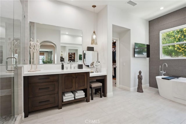 bathroom featuring a shower stall, vanity, a freestanding tub, tile patterned floors, and recessed lighting