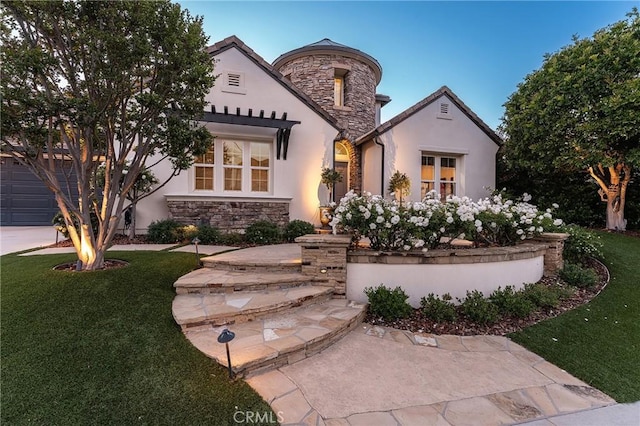 french provincial home with stone siding, stucco siding, and a front yard