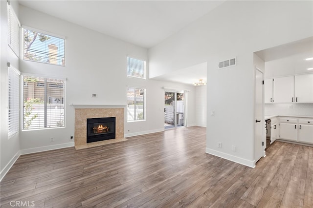 26932 Begonia Pl, Mission Viejo, CA 92692 - unfurnished living room with a high ceiling, a tile fireplace, light wood-style floors, and healthy amount of natural light