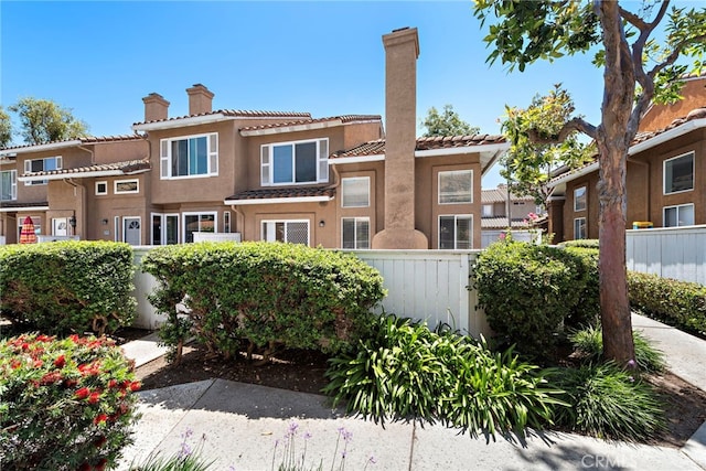 26932 Begonia Pl, Mission Viejo, CA 92692 - rear view of house featuring a chimney, fence, stucco siding, and a tiled roof