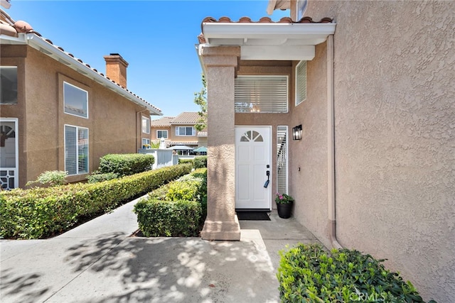 26932 Begonia Pl, Mission Viejo, CA 92692 - doorway to property featuring stucco siding and a chimney
