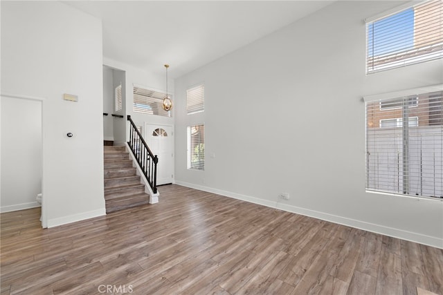 26932 Begonia Pl, Mission Viejo, CA 92692 - empty room with a towering ceiling, stairway, wood finished floors, and baseboards