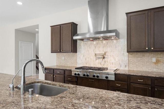 1797 Santa Christina Ave, Chula Vista, CA 91913 - kitchen featuring wall chimney range hood, a sink, stainless steel gas cooktop, dark brown cabinets, and light stone counters