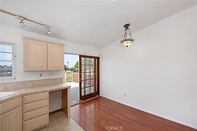 521 S Francisca Ave, Redondo Beach, CA 90277 - kitchen with cream cabinets, tile counters, light wood-style floors, and baseboards