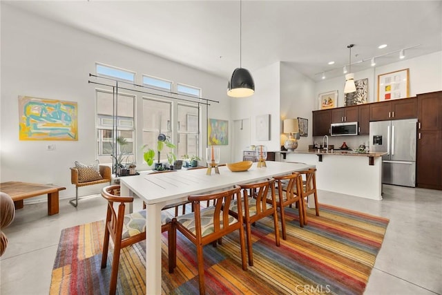 253 N Bush St, Santa Ana, CA 92701 - dining space with a high ceiling, finished concrete flooring, and rail lighting
