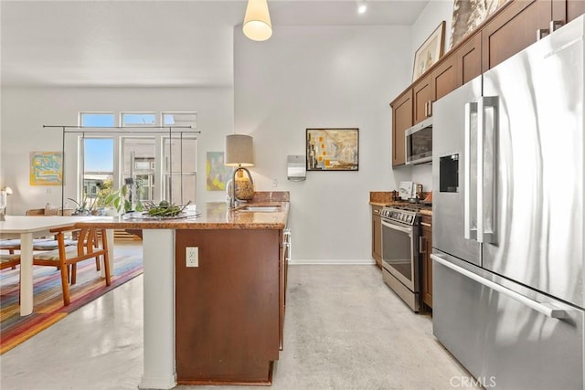 253 N Bush St, Santa Ana, CA 92701 - kitchen featuring stainless steel appliances, concrete flooring, a peninsula, and stone counters