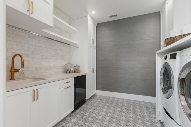 417 Warwick Ave, Cardiff By The Sea, CA 92007 - laundry room featuring beverage cooler, separate washer and dryer, bar area, cabinet space, and baseboards