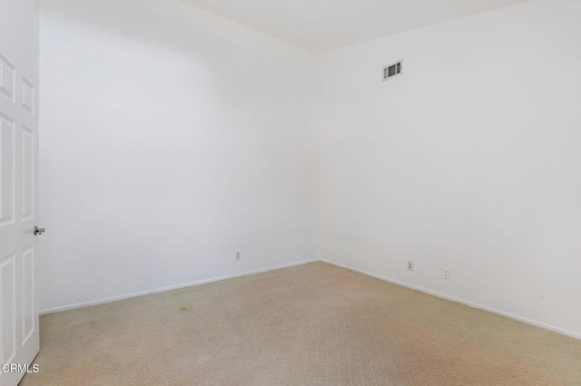 unfurnished room with light carpet and baseboards