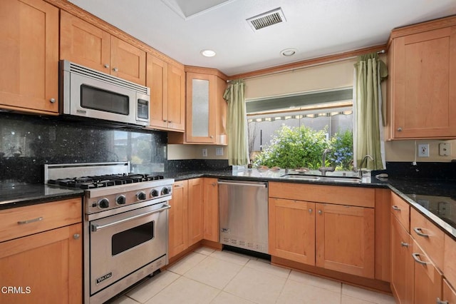 4078 Bending Oak Ct, Moorpark, CA 93021 - kitchen featuring appliances with stainless steel finishes, light tile patterned floors, backsplash, dark stone counters, and glass insert cabinets