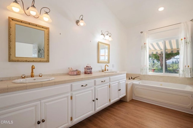 4078 Bending Oak Ct, Moorpark, CA 93021 - bathroom with plenty of natural light, double vanity, vaulted ceiling, a garden tub, and wood finished floors