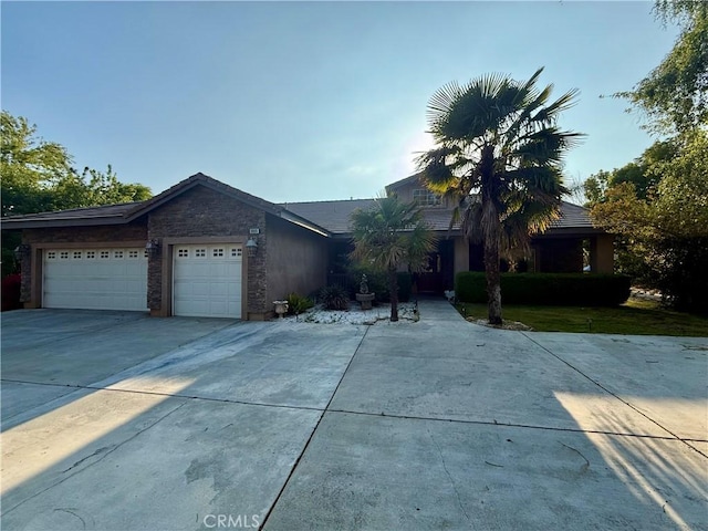 9869 Kehl Canyon Rd, Cherry Valley, CA 92223 - view of front facade with an attached garage, driveway, and stone siding