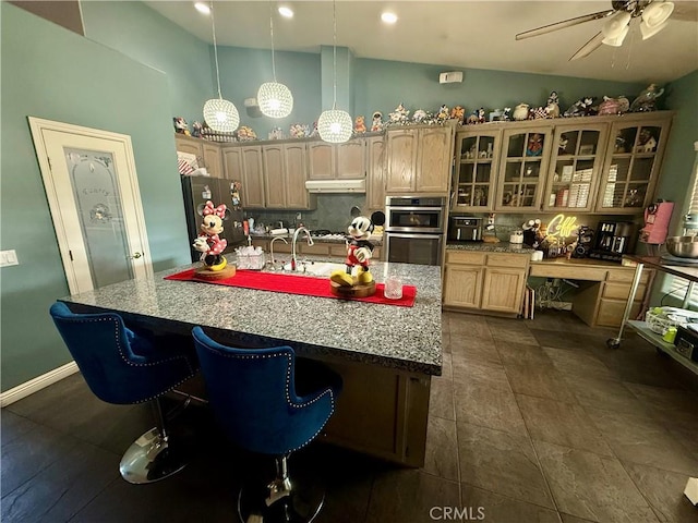 9869 Kehl Canyon Rd, Cherry Valley, CA 92223 - kitchen featuring appliances with stainless steel finishes, under cabinet range hood, a ceiling fan, a kitchen island with sink, and glass insert cabinets