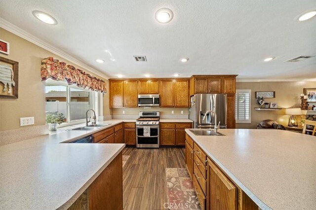 1266 Marina Rd, Corona, CA 92880 - kitchen featuring stainless steel appliances, a sink, brown cabinetry, ornamental molding, and light countertops