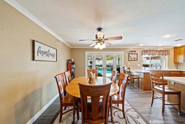 1266 Marina Rd, Corona, CA 92880 - dining area featuring dark wood-type flooring, french doors, crown molding, a ceiling fan, and baseboards