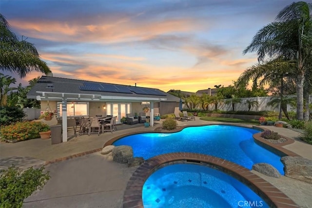 1266 Marina Rd, Corona, CA 92880 - pool at dusk featuring outdoor dining space, a patio, a fenced backyard, french doors, and a pool with connected hot tub