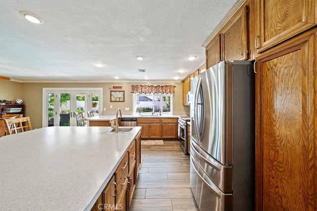 1266 Marina Rd, Corona, CA 92880 - kitchen featuring stainless steel appliances, brown cabinets, a sink, light countertops, and french doors