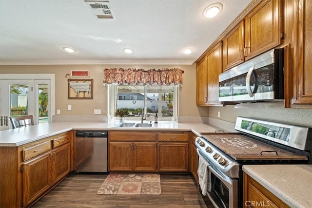1266 Marina Rd, Corona, CA 92880 - kitchen featuring stainless steel appliances, a sink, brown cabinetry, a peninsula, and light countertops