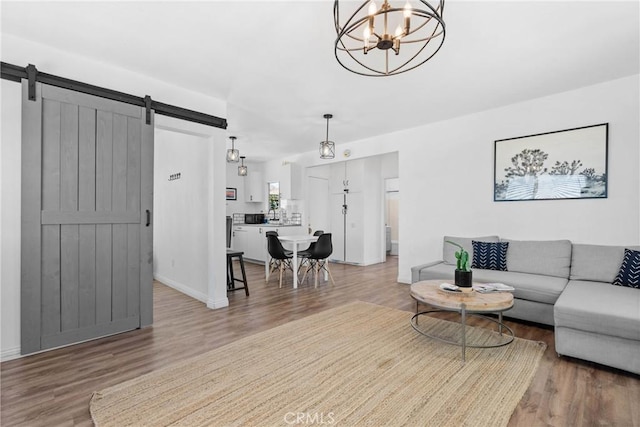 59101 Joshua Dr, Yucca Valley, CA 92284 - living room featuring a barn door, light wood-style floors, a chandelier, and baseboards