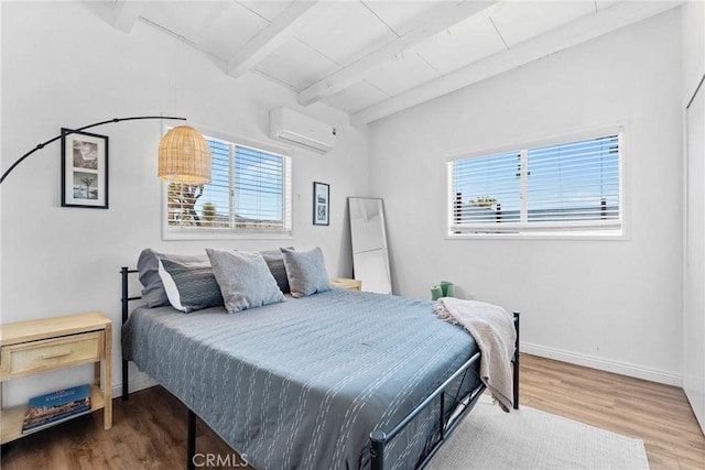 59101 Joshua Dr, Yucca Valley, CA 92284 - bedroom with a wall mounted AC, multiple windows, wood finished floors, and baseboards