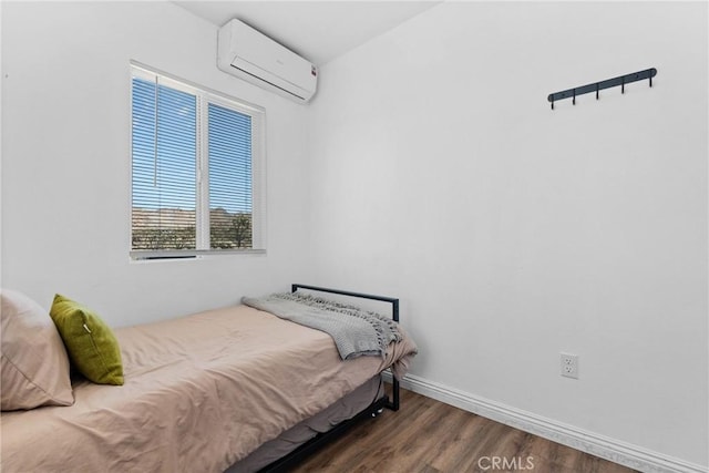 59101 Joshua Dr, Yucca Valley, CA 92284 - bedroom with an AC wall unit, wood finished floors, and baseboards