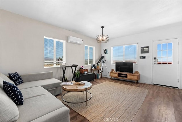 59101 Joshua Dr, Yucca Valley, CA 92284 - living room with a wall unit AC, wood finished floors, plenty of natural light, and a chandelier
