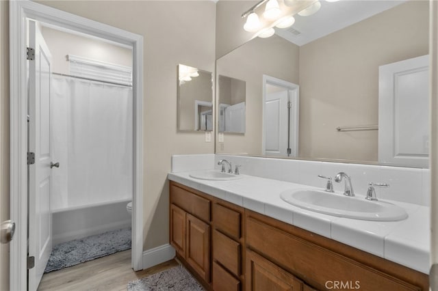 14215 Rolling Stream Pl, Eastvale, CA 92880 - bathroom featuring wood finished floors, double vanity, toilet, shower / bathtub combination with curtain, and baseboards