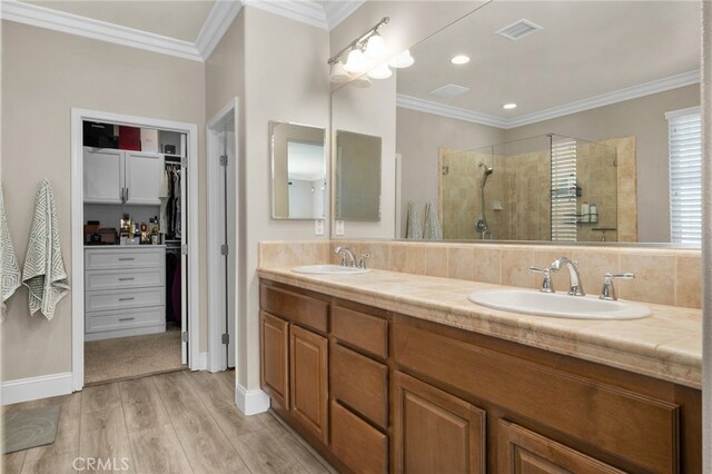 14215 Rolling Stream Pl, Eastvale, CA 92880 - bathroom with wood finished floors, tiled shower, a walk in closet, ornamental molding, and double vanity