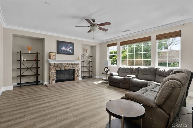 14215 Rolling Stream Pl, Eastvale, CA 92880 - living area with light wood finished floors, a ceiling fan, baseboards, crown molding, and a stone fireplace