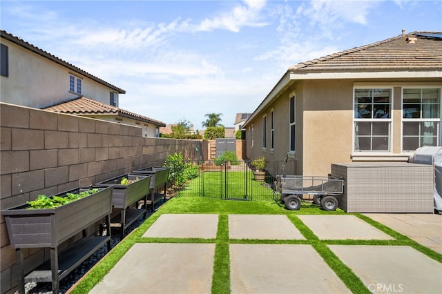 14215 Rolling Stream Pl, Eastvale, CA 92880 - view of yard featuring a vegetable garden, a gate, and a patio