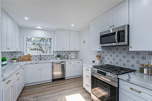 654 Carina Dr, Lompoc, CA 93436 - kitchen with appliances with stainless steel finishes, white cabinetry, light stone counters, decorative backsplash, and recessed lighting
